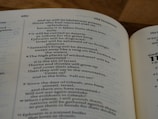 A close-up view of an open book displaying text from the Old Testament. The page is slightly curved with text that includes chapter and verse numbers. The paper color is off-white, and the text is in black.