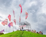 A group of supporters cheering along the mountain trail with colorful banners and flags