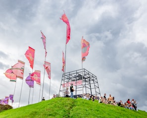 A group of supporters cheering along the mountain trail with colorful banners and flags