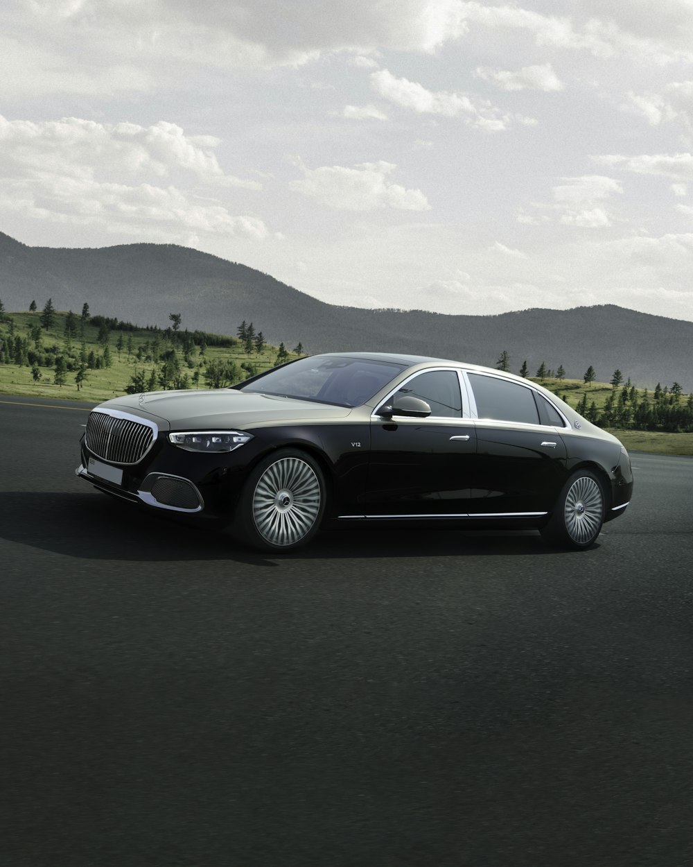 a black car driving down a road next to a forest