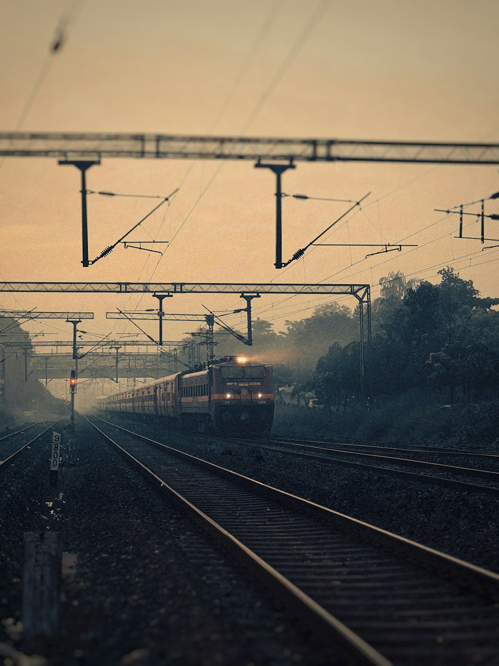 a train traveling down train tracks next to a forest