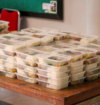 a table topped with plastic containers filled with food