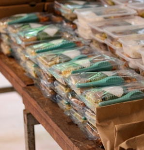 a table filled with plastic containers and bags of food