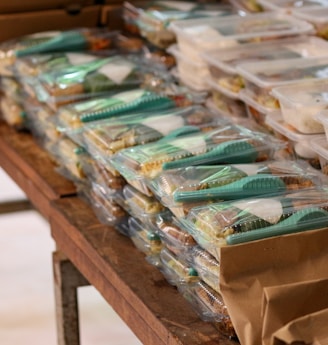 a table filled with plastic containers and bags of food