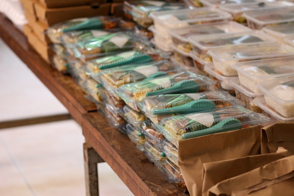 a table filled with plastic containers and bags of food