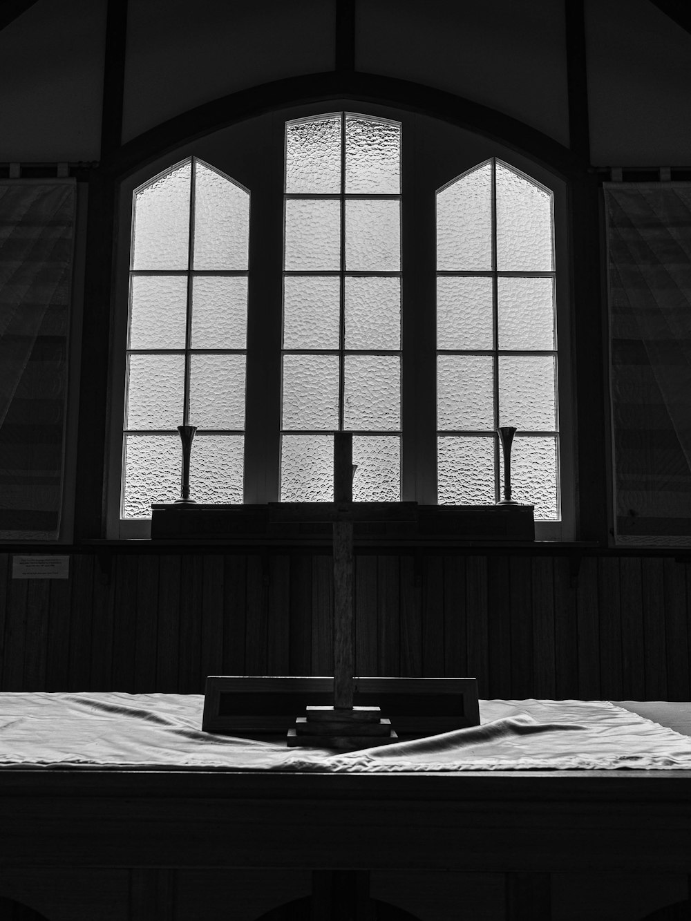 a cross in front of a window in a church