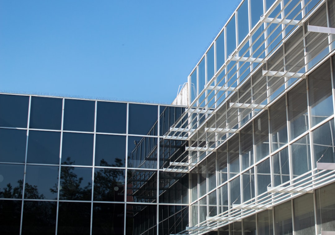 a tall building with many windows next to a tree, Structural photography
