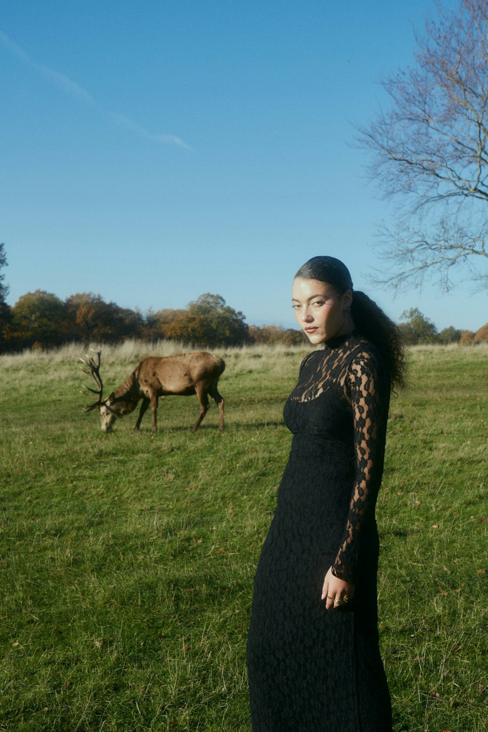 a woman in a black dress standing in a field