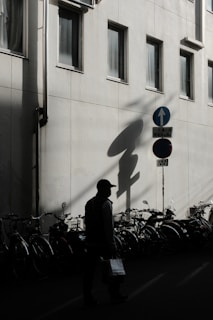 a man walking down a street next to a tall building