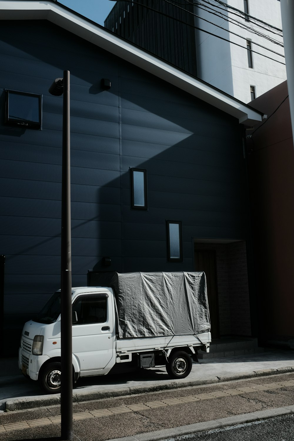 a white truck parked next to a tall building