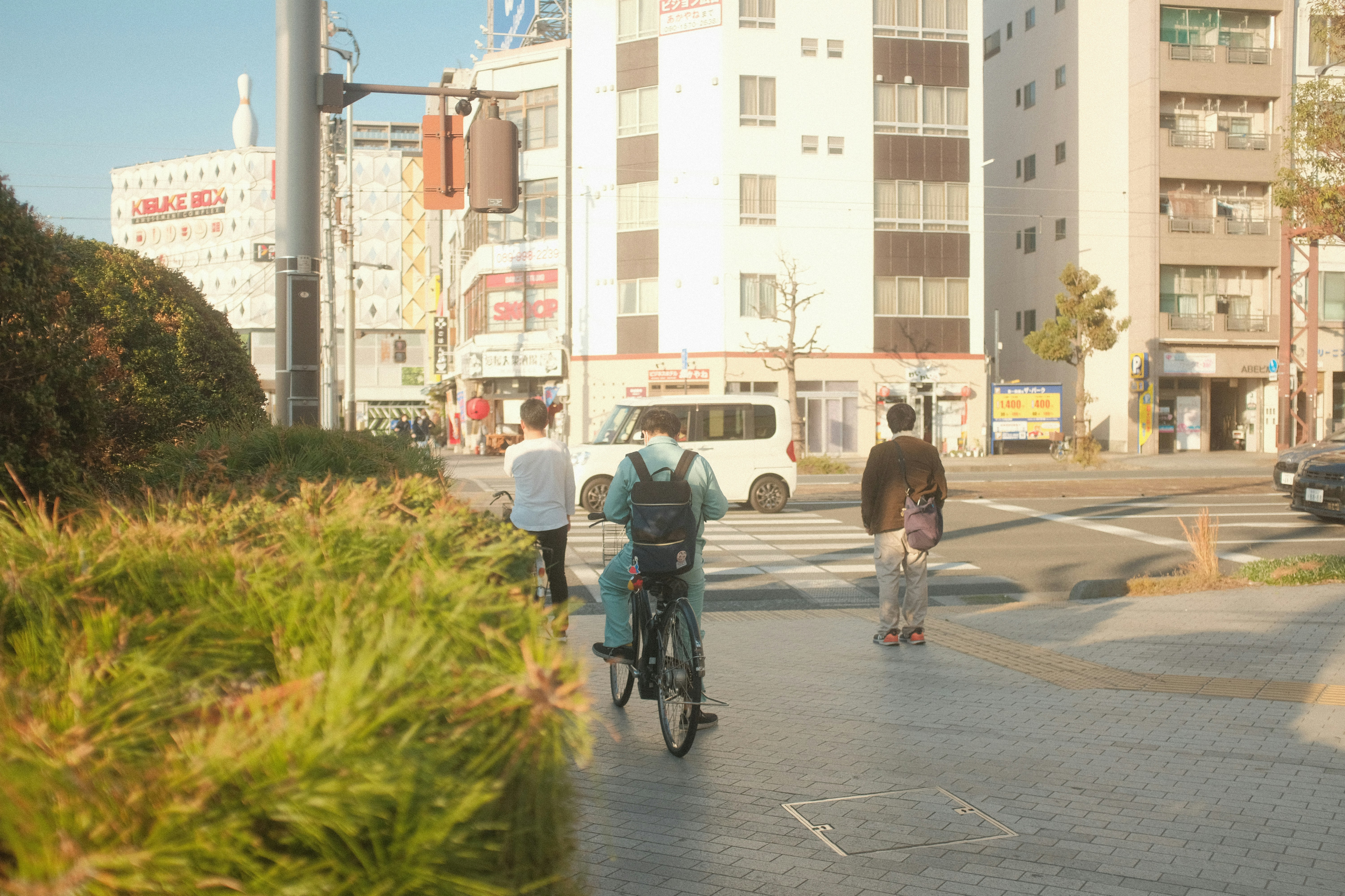 a man riding a bike down a street next to tall buildings