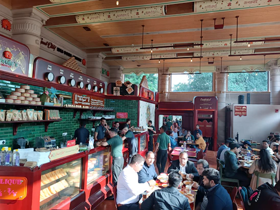 Warm, inviting interior of Baski Cafe with customers enjoying steaming cups of tea around wooden tables.