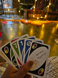 Hands holding colorful game cards with reflective prompts.