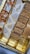 An assortment of Indian sweets presented in a box, featuring different types including those topped with silver foil. The sweets are divided into sections, showcasing a variety of colors and textures.