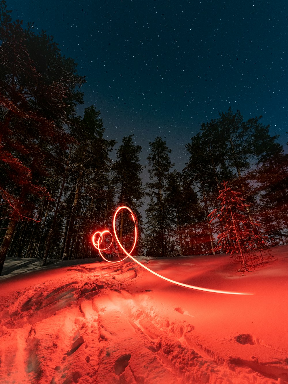 a red light painting of two hearts in the snow