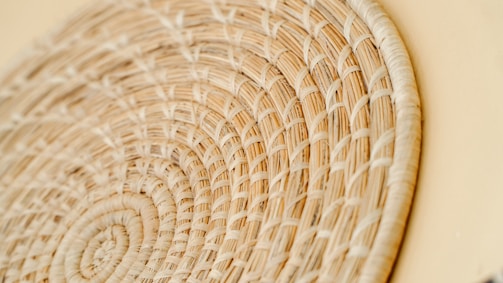 Close-up of hands weaving natural fibers into a beautiful handcrafted basket.