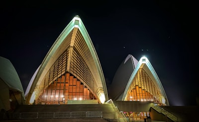 A nighttime view of a bespoke architectural structure illuminated to highlight its unique contours.