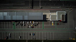 Wide shot of a newly striped parking lot outside a busy commercial building.