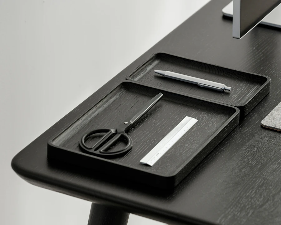 Sectioned wooden desk organizer holding pens and small tools