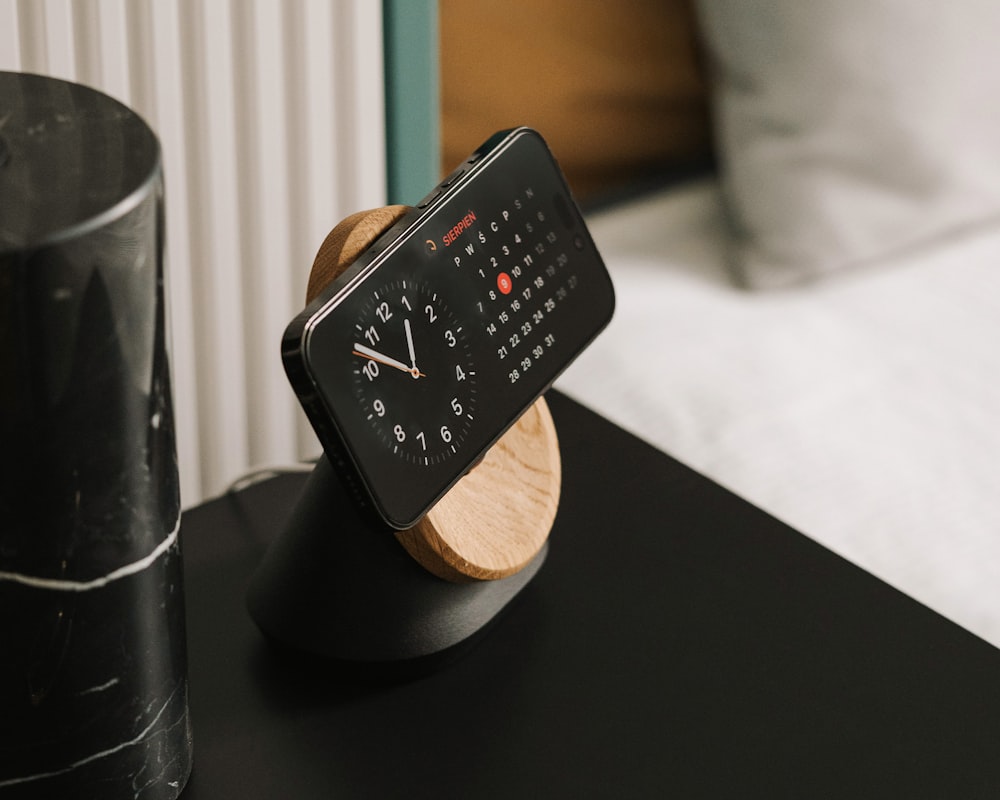 a wooden clock sitting on top of a black table