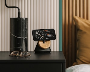 An elegant bedroom setup with a smart alarm clock casting a soft blue glow on a minimalist nightstand