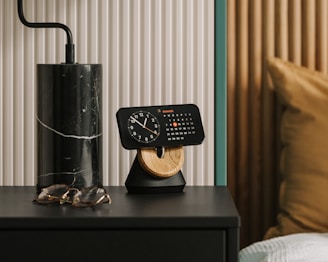 An elegant bedroom setup with a smart alarm clock casting a soft blue glow on a minimalist nightstand