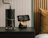 Minimalist bedroom with a floating nightstand holding a lamp and a small clock.