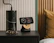 Minimalist bedroom with a floating nightstand holding a lamp and a small clock.