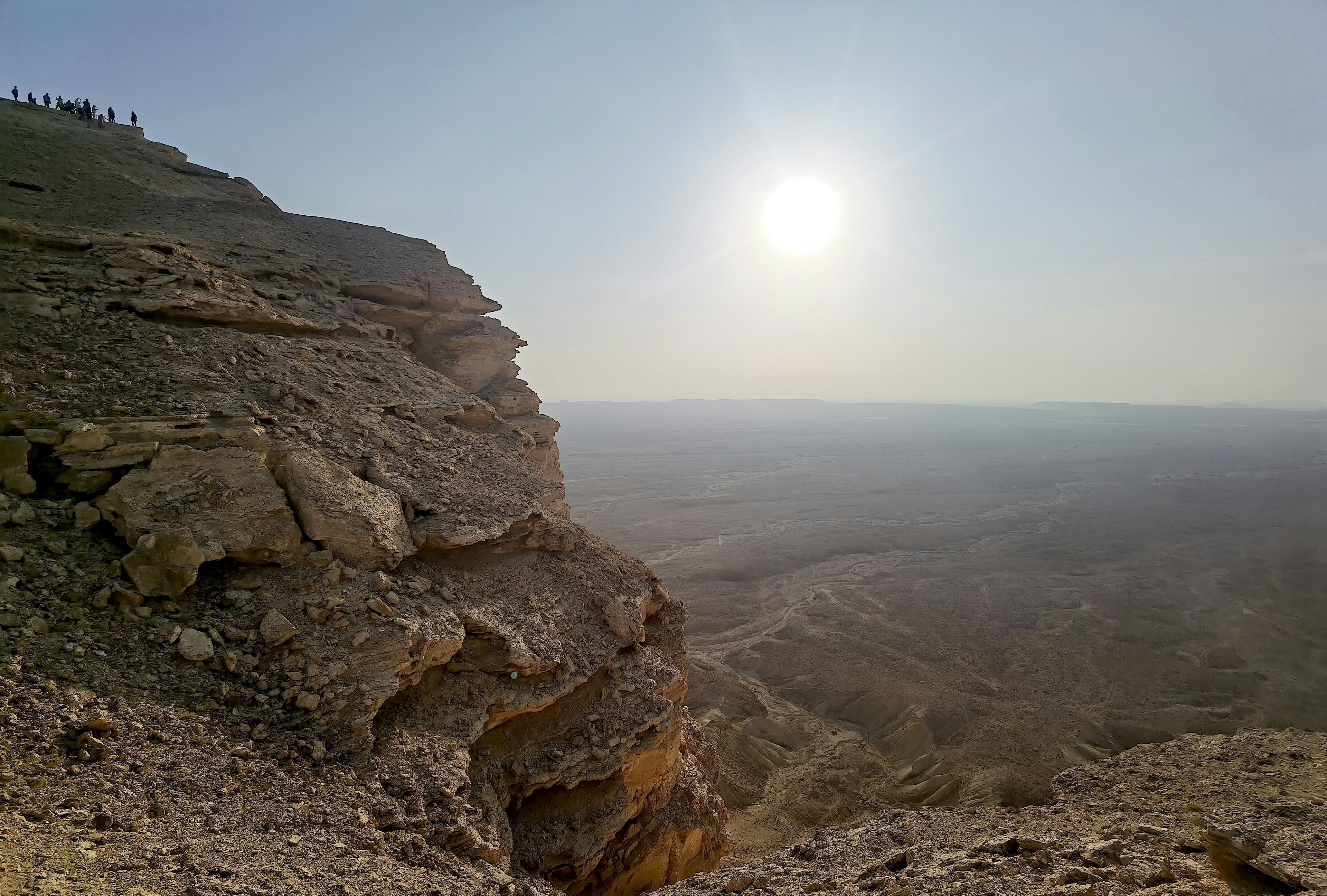 a group of people standing on top of a cliff