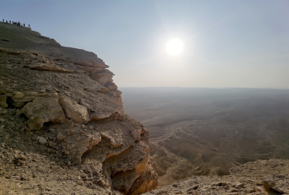 a group of people standing on top of a cliff