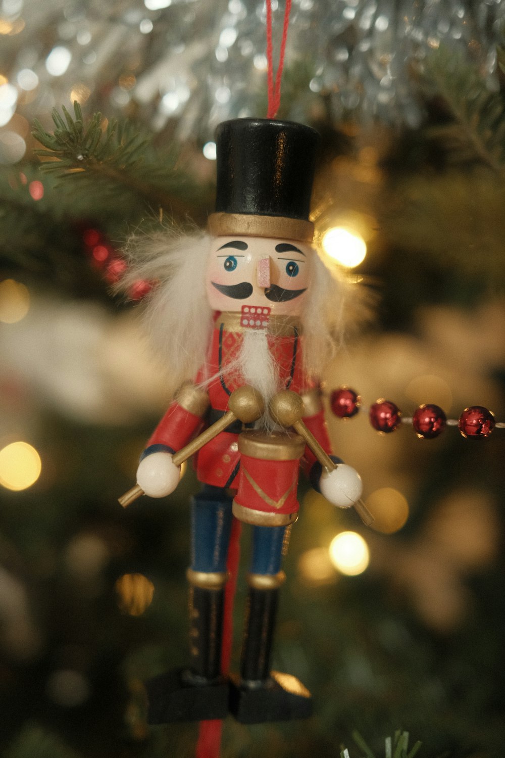 a nutcracker ornament hanging from a christmas tree