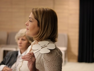 a woman standing next to another woman in a room