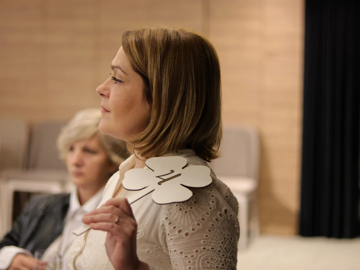 Two women standing together in a room, mid-conversation