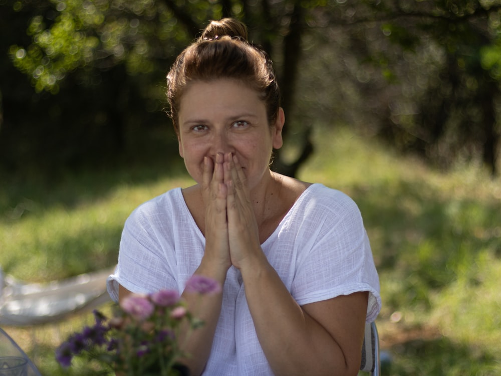 a woman covering her mouth with her hands