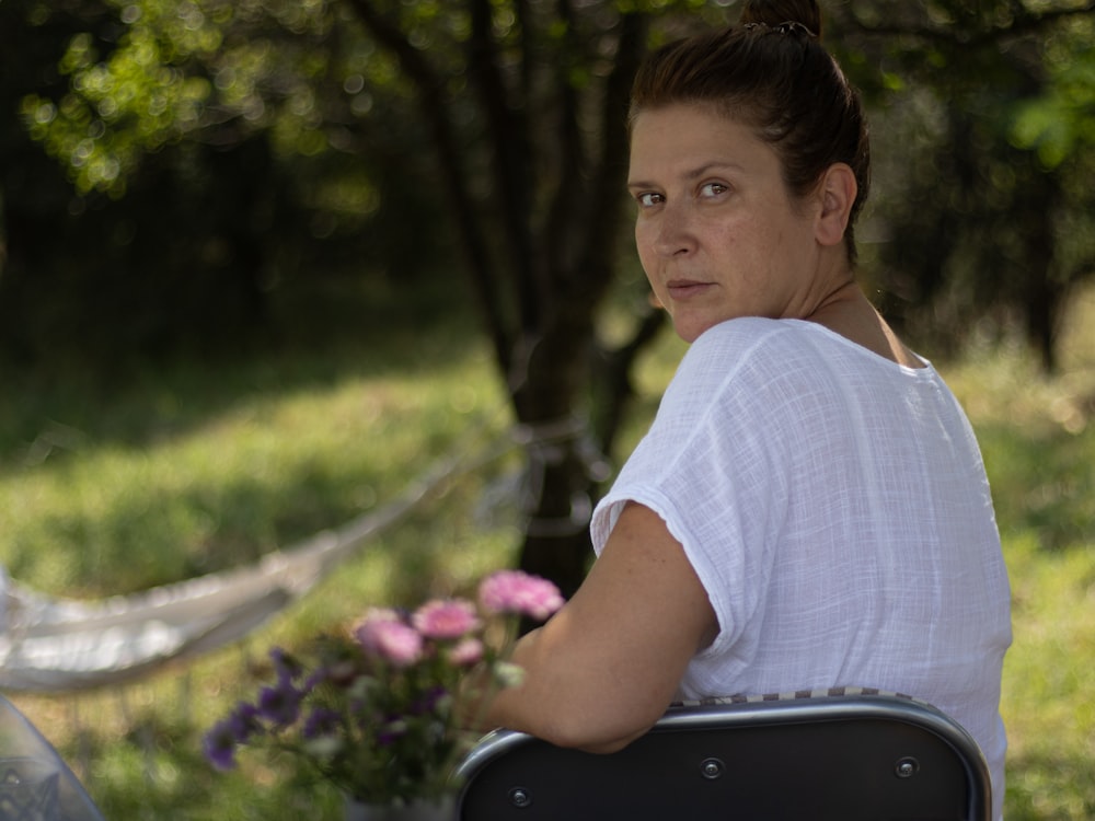 a woman sitting in a hammock in a park