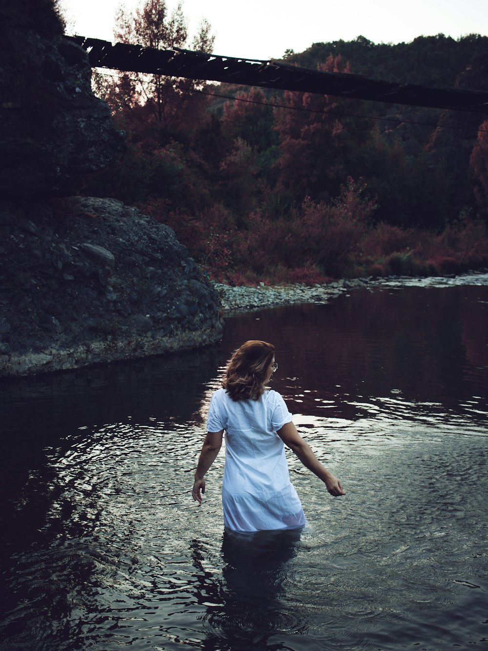 a woman wading through a body of water