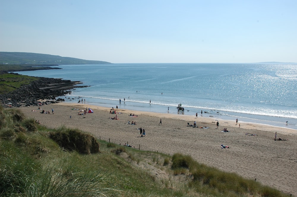 a group of people standing on top of a sandy beach