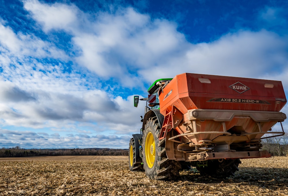 a red tractor is parked in the middle of a field