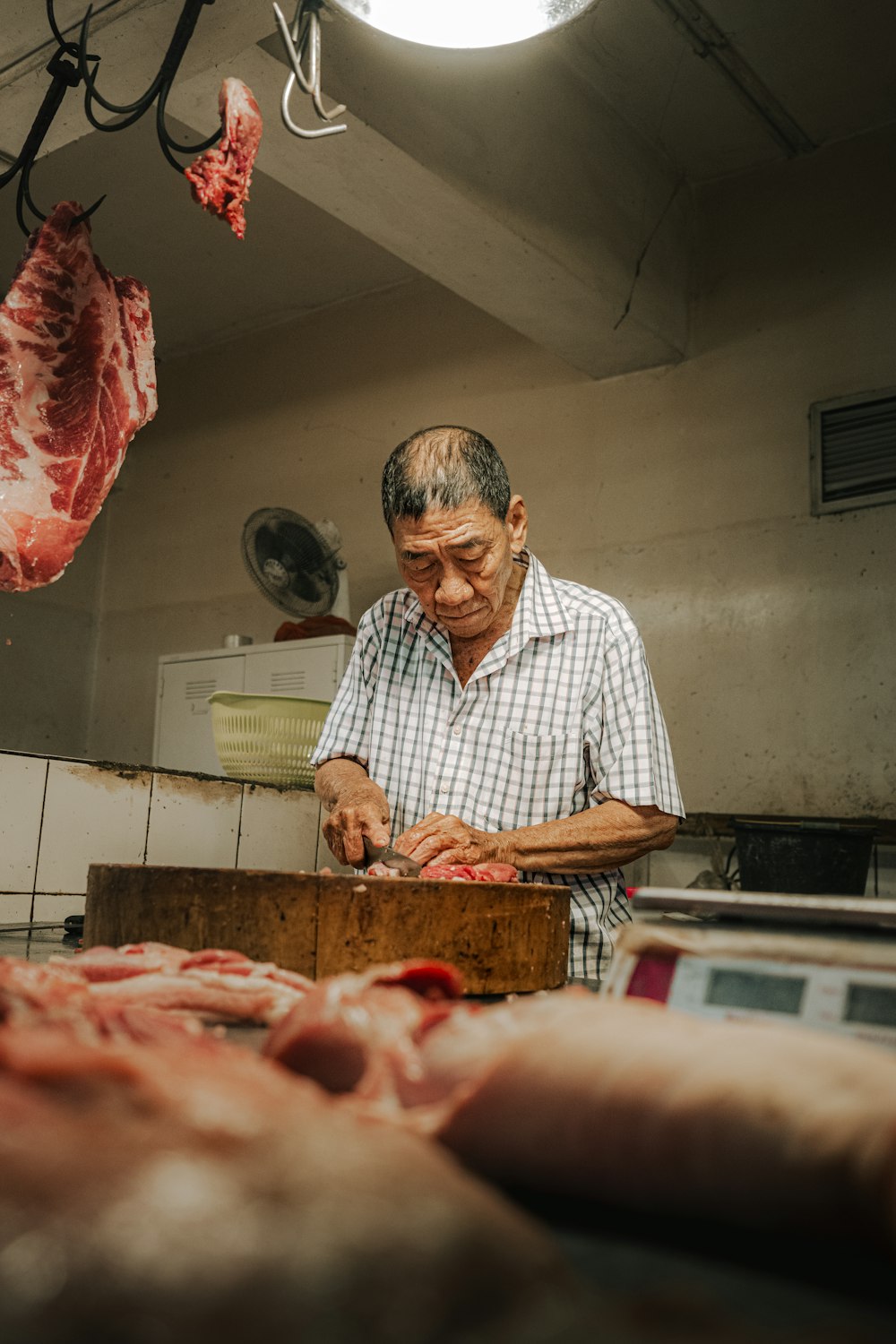 a man in a butcher shop slicing meat