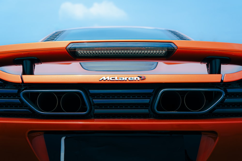 a close up of the front of an orange sports car