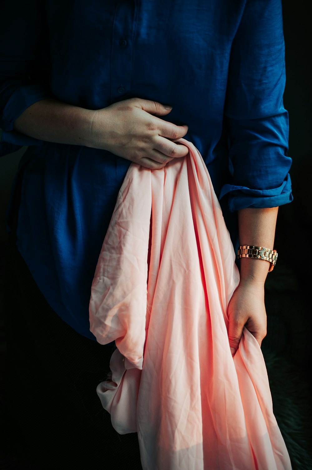 a woman holding a pink blanket in her hands