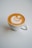 A steaming cup of coffee with a beautiful latte art design on top.