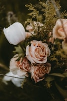 Close-up of a refined bridal bouquet featuring blush beige and warm stone flowers with delicate greenery.