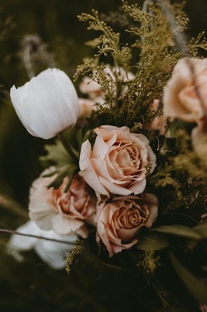 Close-up of a refined bridal bouquet featuring blush beige and warm stone flowers with delicate greenery.