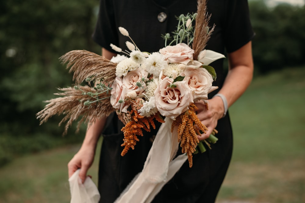 a woman holding a bouquet of flowers in her hands