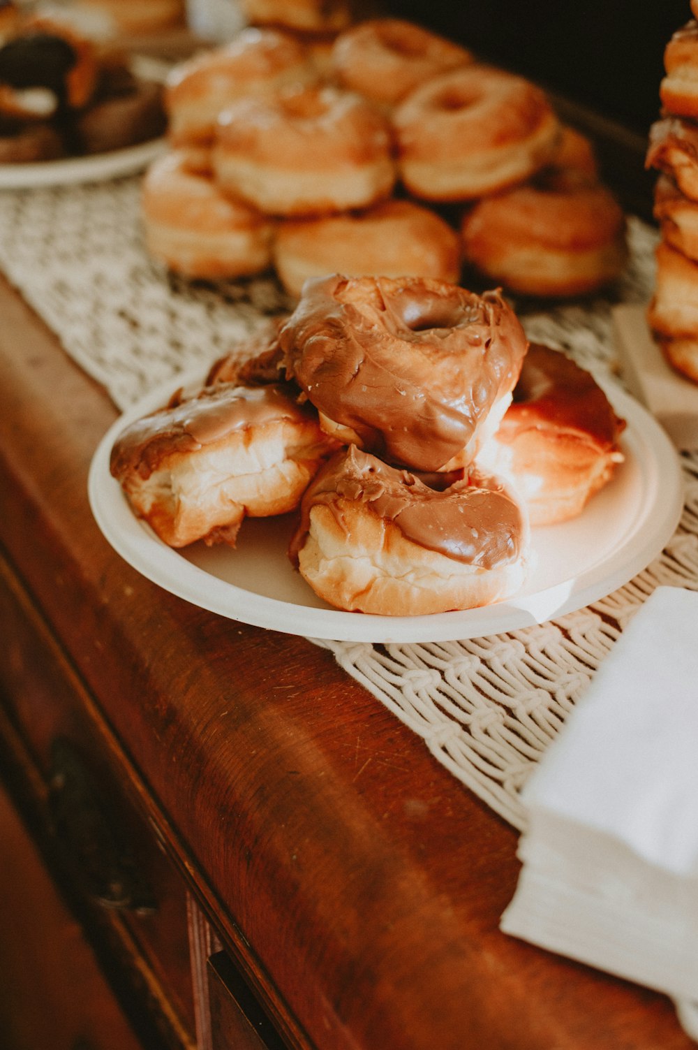 a table topped with lots of donuts on top of a white plate