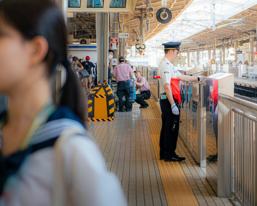 a man in uniform standing at a train station