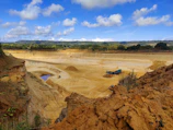 Panoramic view of the Pedreira Ervália quarry with trucks and machinery.