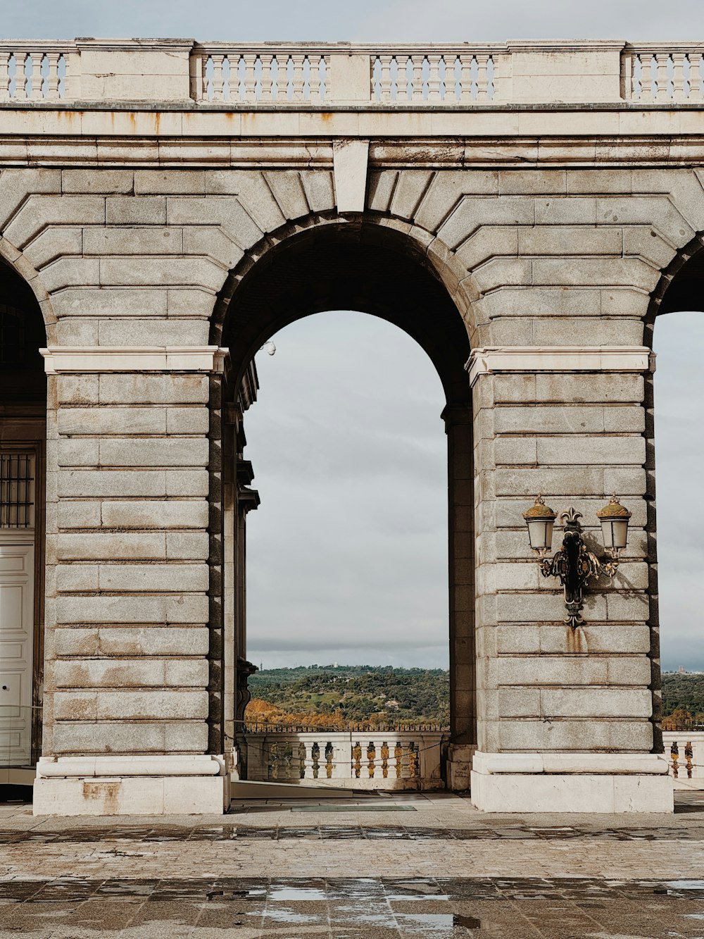 a stone arch with a clock on the side of it