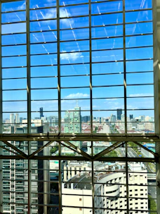 A detailed architectural blueprint spread out on a desk with a city skyline visible through the window.